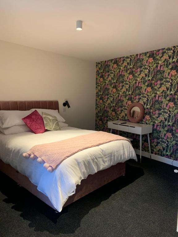 sypialnia z dużym łóżkiem i tapetą w kwiaty w obiekcie STAG & THISTLE HOTEL AND RESTAURANT w mieście Fraserburgh