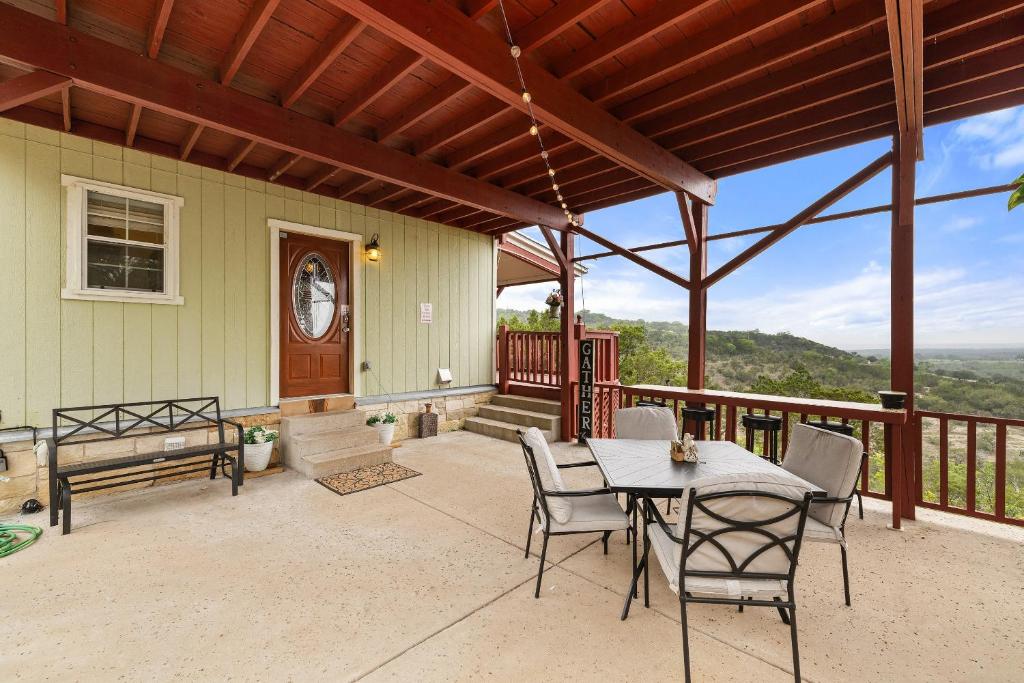 a patio with a table and chairs on a balcony at Entire 2br 2ba hilltop view home Sleeps 8 pets 4 acres Jacuzzi Central AC Kingbeds Free Wifi-Parking Kitchen WasherDryer Starry Terrace Two Sunset Dining Patios Grill Stovetop Oven Fridge OnsiteWoodedHiking Wildlife CoveredPatio4pets & Birds Singing! in Marble Falls