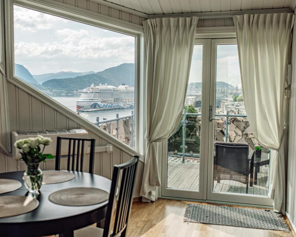 a dining room with a balcony with a view of a cruise ship at Panorama Apartment with 360 view of the city Ålesund in Ålesund