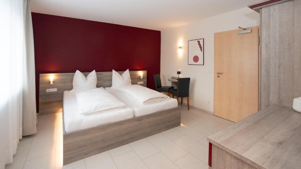 Schlafzimmer mit einem großen weißen Bett und einer roten Wand in der Unterkunft ERSTAY in Dorsten