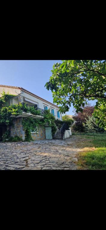 un bâtiment situé au sommet d'une cour en pierre dans l'établissement Appartement St montan, à Saint-Montan