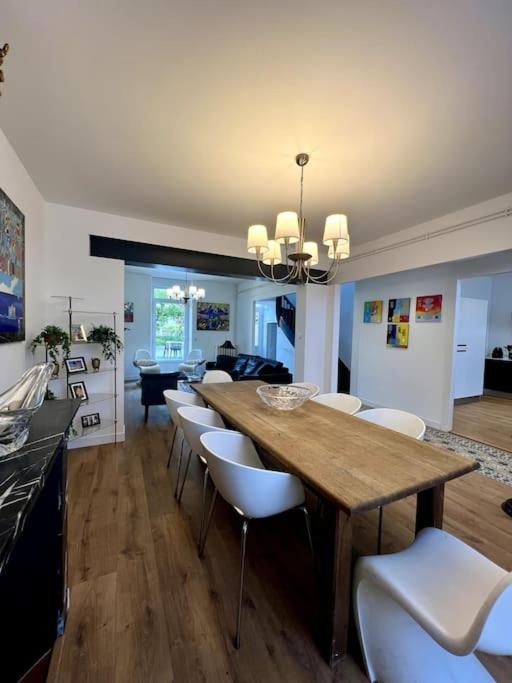 une salle à manger avec une grande table en bois et des chaises blanches dans l'établissement Villa Eden - 9 pers, à Charleville-Mézières