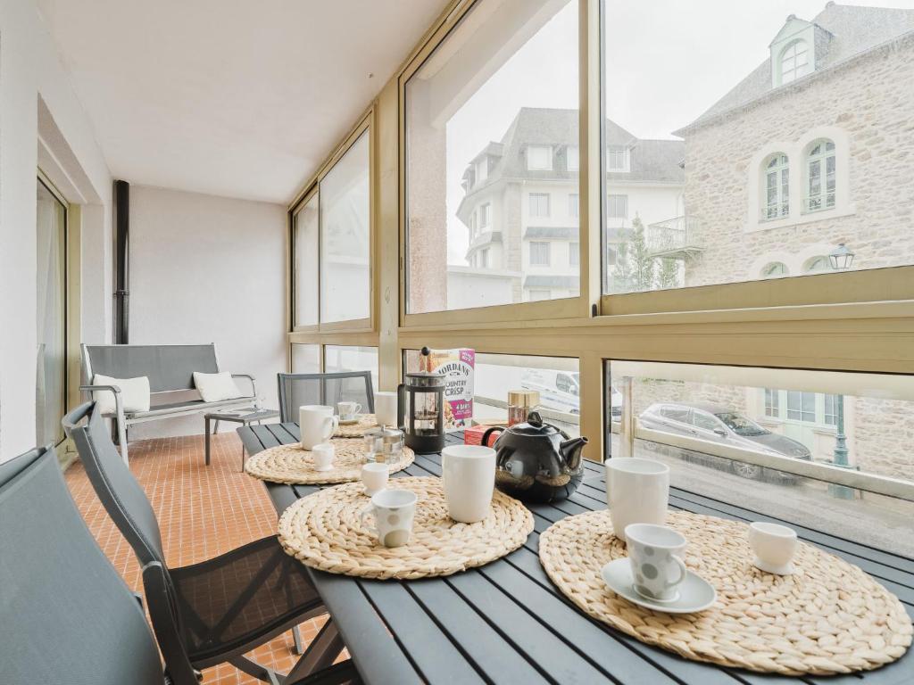 deux tables avec des tasses et des soucoupes dessus sur un balcon dans l'établissement Apartment Le Victor Hugo by Interhome, à Dinard