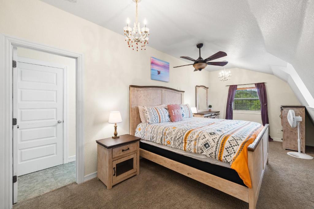 a bedroom with a bed and a ceiling fan at Entire 2br 2ba hilltop view home Sleeps 8 pets 4 acres Jacuzzi Central AC Kingbeds Free Wifi-Parking Kitchen WasherDryer Starry Terrace Two Sunset Dining Patios Grill Stovetop Oven Fridge OnsiteWoodedHiking Wildlife CoveredPatio4pets & Birds Singing! in Marble Falls