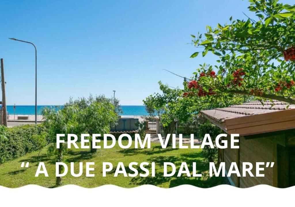 um sinal que lê a vila da liberdade um passe justo dla gerenciar em Freedom Village em Soverato Marina