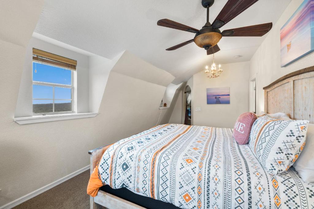 a bedroom with a bed and a ceiling fan at Entire 2br 2ba hilltop view home Sleeps 8 pets 4 acres Jacuzzi Central AC Kingbeds Free Wifi-Parking Kitchen WasherDryer Starry Terrace Two Sunset Dining Patios Grill Stovetop Oven Fridge OnsiteWoodedHiking Wildlife CoveredPatio4pets & Birds Singing! in Marble Falls