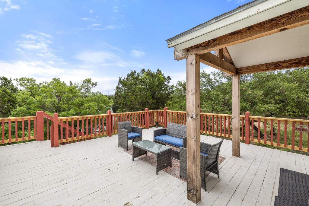 a wooden deck with benches and a gazebo at Entire 2br 2ba hilltop view home Sleeps 8 pets 4 acres Jacuzzi Central AC Kingbeds Free Wifi-Parking Kitchen WasherDryer Starry Terrace Two Sunset Dining Patios Grill Stovetop Oven Fridge OnsiteWoodedHiking Wildlife CoveredPatio4pets & Birds Singing! in Marble Falls