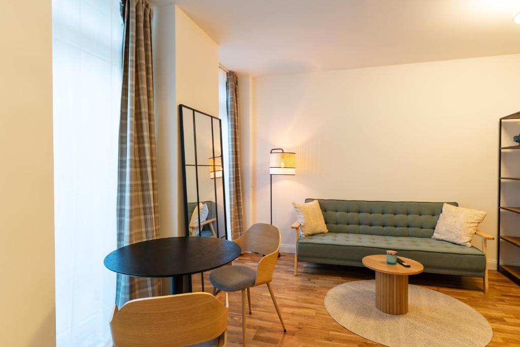 uma sala de estar com um sofá, uma mesa e cadeiras em bevoflats - Zentrales Souterrain in Kreuzberg em Berlim