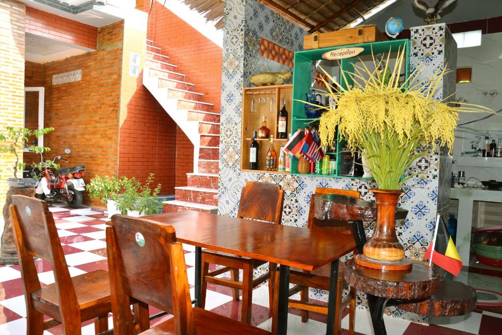 a wooden table with chairs and a vase with a plant on it at BOSA Homestay - Mekong Riverside in Can Tho