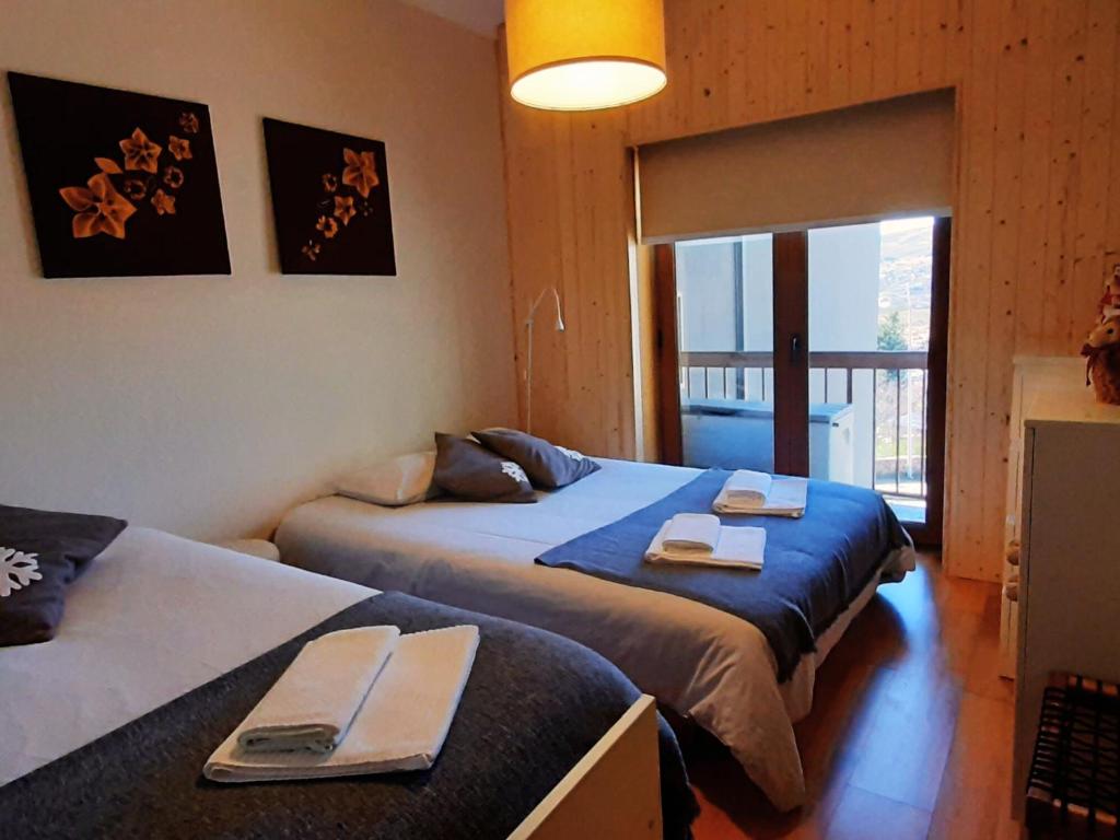 1 dormitorio con 2 camas y toallas. en Casa da Serra - T1 - Penhas da Saúde en Penhas da Saúde