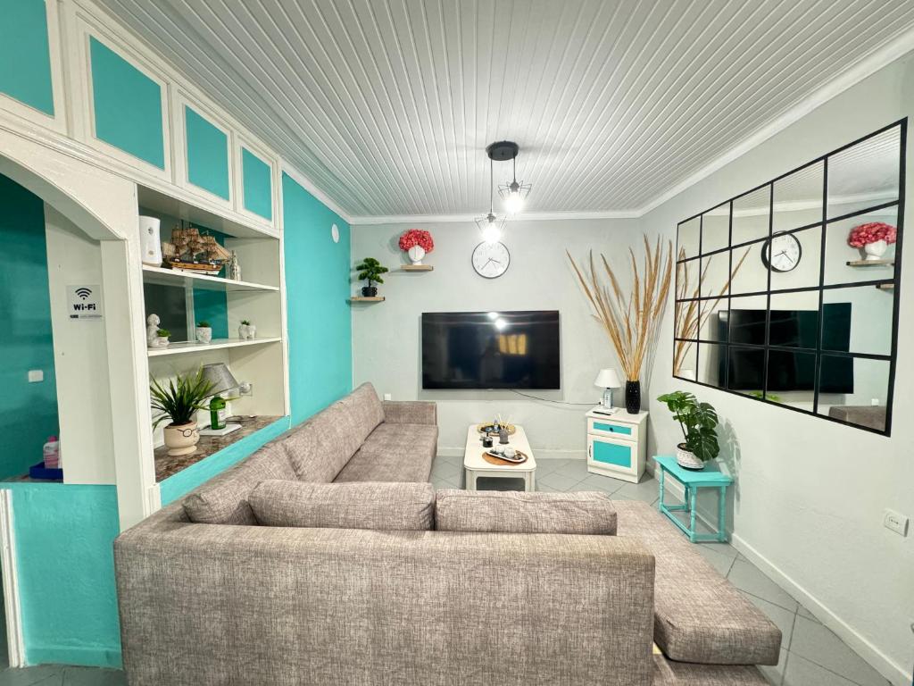 ein Wohnzimmer mit Sofa und Flachbildfernseher in der Unterkunft Mykonos Seaside Villa in Paralía Avdhíron