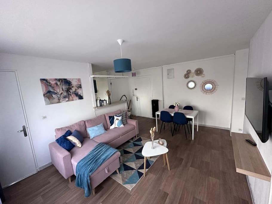 un salon avec un canapé violet et une table dans l'établissement Bel appartement, chambre et salon à Metz centre, à Metz