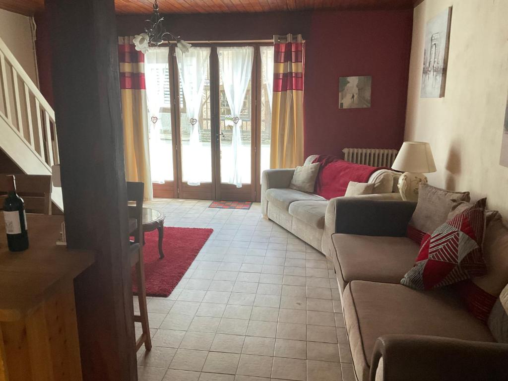 a living room with two couches and a table at Maison de Rêve in Notre-Dame-du-Touchet
