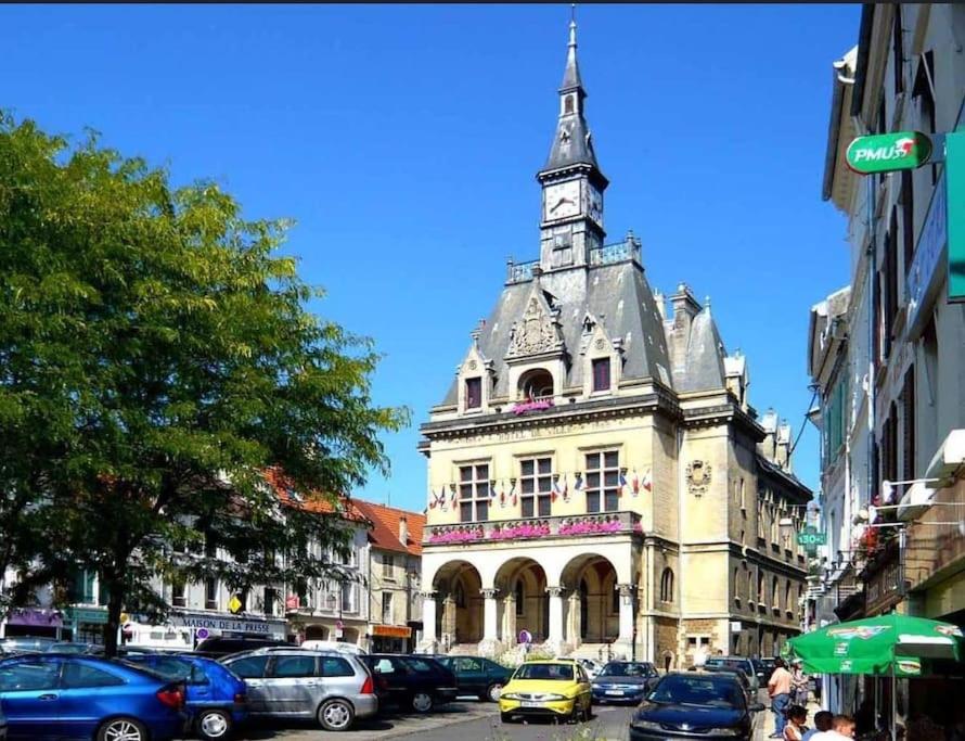 un bâtiment avec une tour d'horloge dans une rue de la ville dans l'établissement studio coup de cœur Disney, à La Ferté-sous-Jouarre