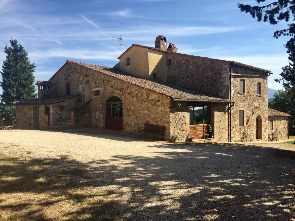 an old stone building with a driveway in front of it at Agriturismo Le Querciole in Val d'Orcia in Bagno Vignoni