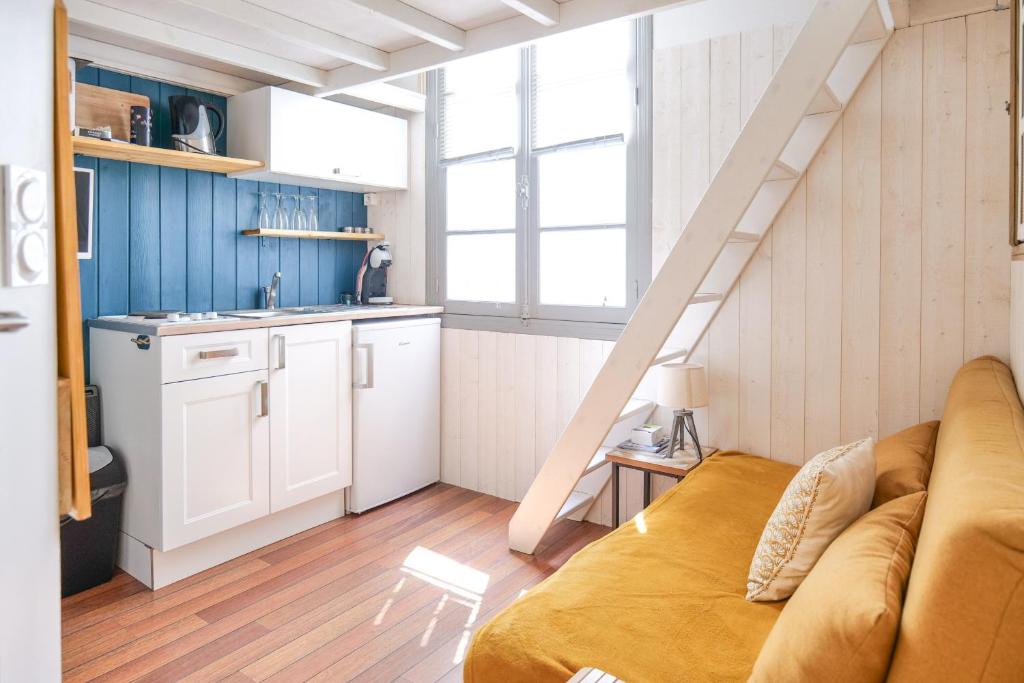 un salon avec un canapé et une cuisine dans l'établissement charmante studette remblai des sables d olonne, à Les Sables-dʼOlonne