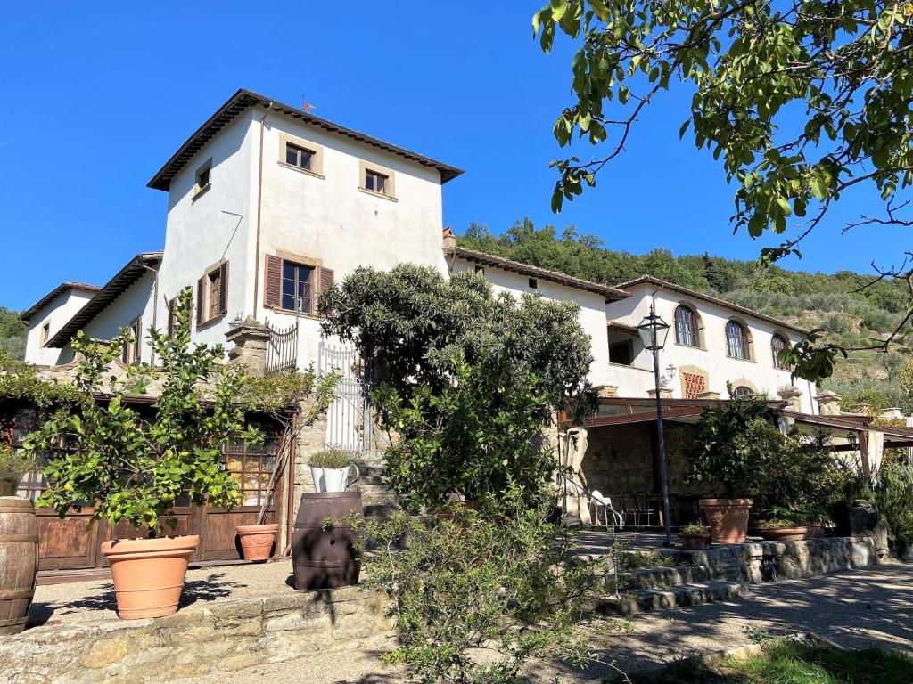 Una casa vieja con un perro delante. en Apartment Villa Grassina-4 by Interhome, en Pelago