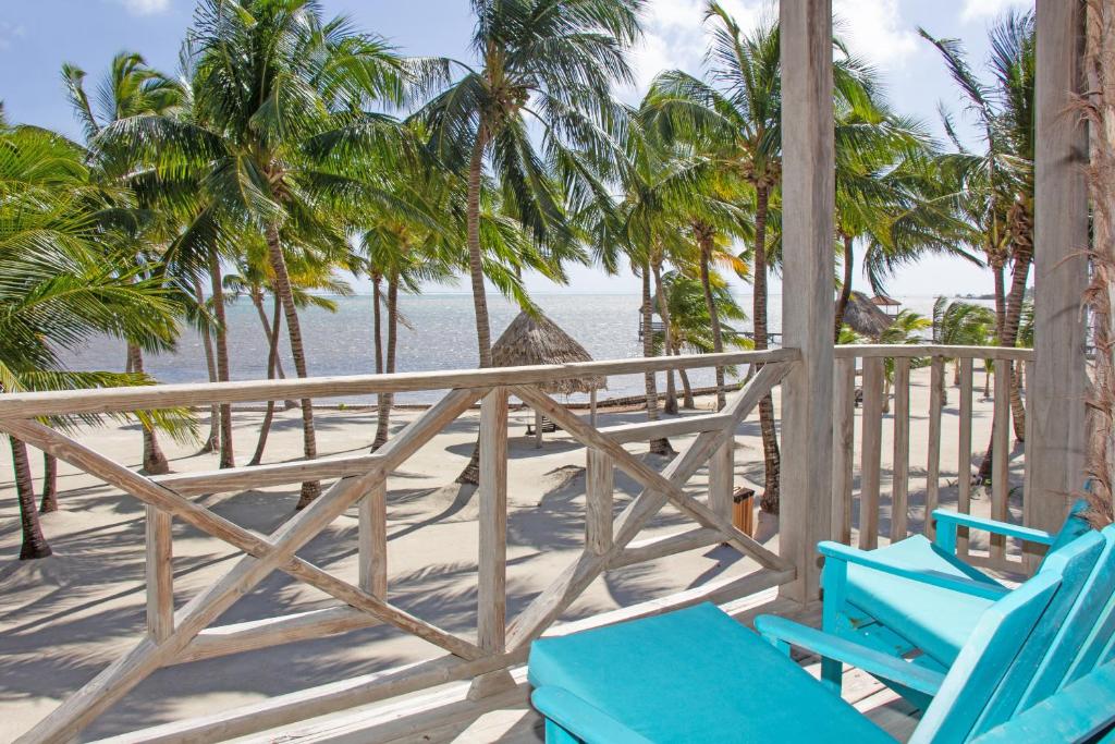 - une terrasse couverte avec des chaises bleues et la plage dans l'établissement C4 - Villa McDonald, à San Pedro