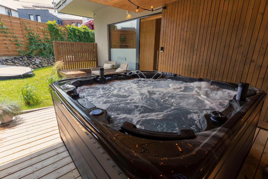 a hot tub sitting on a deck in a backyard at BOHO Butikowe Apartamenty Jastrzębia Góra in Jastrzębia Góra
