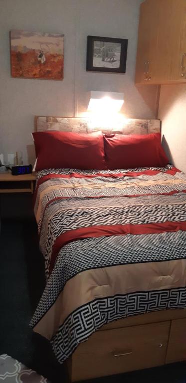 een slaapkamer met een bed met rode kussens en bitterheid bij Peace and Quiet in Lac La Biche