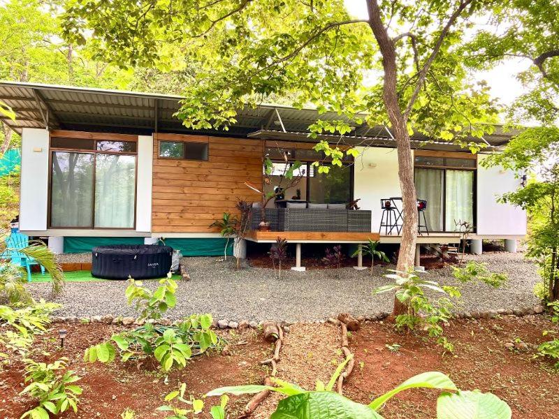 a house with a porch and a bench in front of it at Casa Eden in Tamarindo