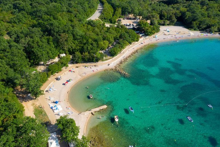 an aerial view of a beach with people in the water at Krk Njivice in Njivice