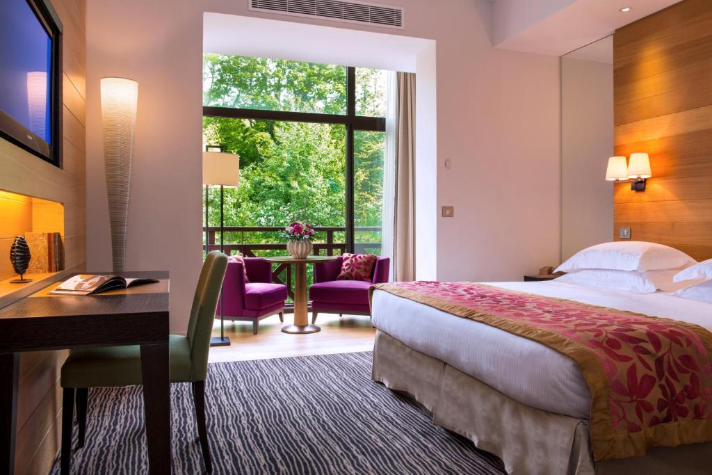 Postel nebo postele na pokoji v ubytování Hôtel Ermitage