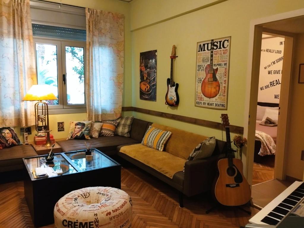 uma sala de estar com um sofá e guitarras na parede em Still got the blues em Atenas