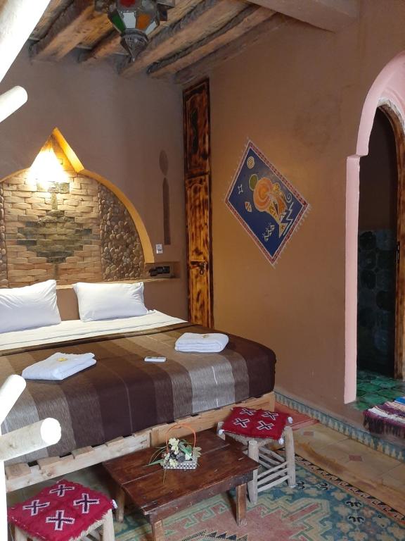 a bedroom with a bed in a room at Auberge Kasbah Dar Sahara Tours in Mhamid