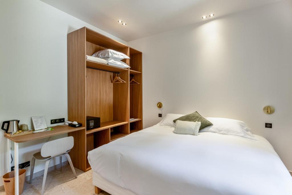 a bedroom with a large white bed and a desk at La Garoupe-Gardiole in Antibes