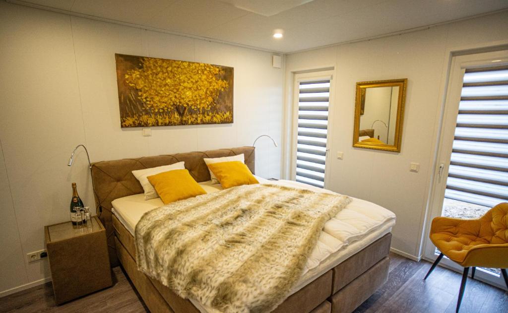 a bedroom with a bed with yellow pillows and a painting at Seepark Cox in Goch