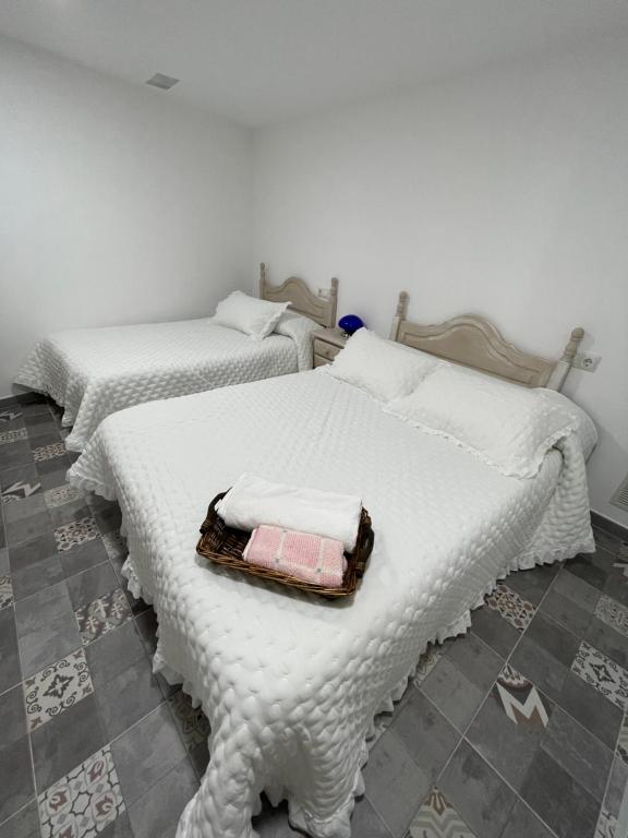 2 Betten mit weißen Decken und Handtüchern darauf in der Unterkunft El rincón coqueto de fina in Orce