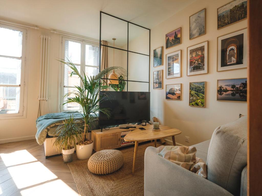 un salon avec une télévision et une table dans l'établissement Appartement Studio Paris La Défense, à Suresnes