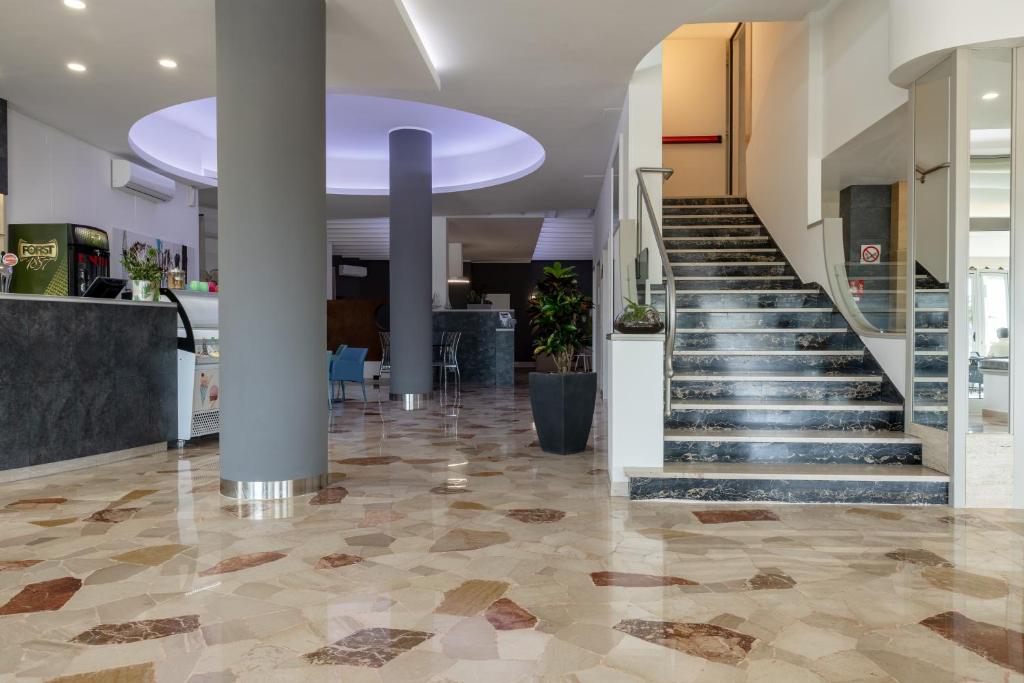 a lobby with a staircase in a building at Hotel Continental in Caorle