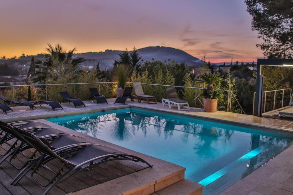 a swimming pool with chairs and a view of a city at Villa d'exception au Beausset avec piscine chauffée in Le Beausset