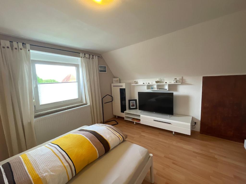 a bedroom with a bed and a tv and a window at Feld PU1 in Laboe
