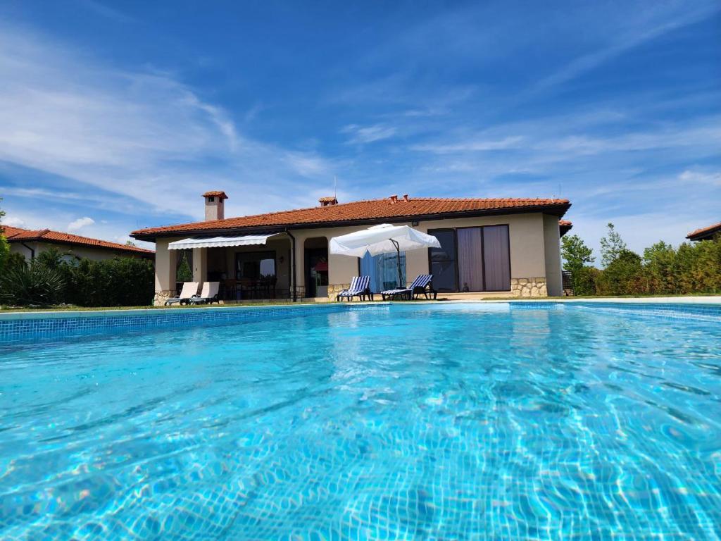 uma villa com piscina em frente a uma casa em Private Villa 102 in BlackSeaRama em Balchik