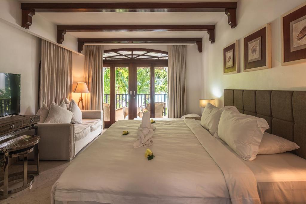 貝聖安那的住宿－漁村酒店，一间带大床的卧室和一间客厅