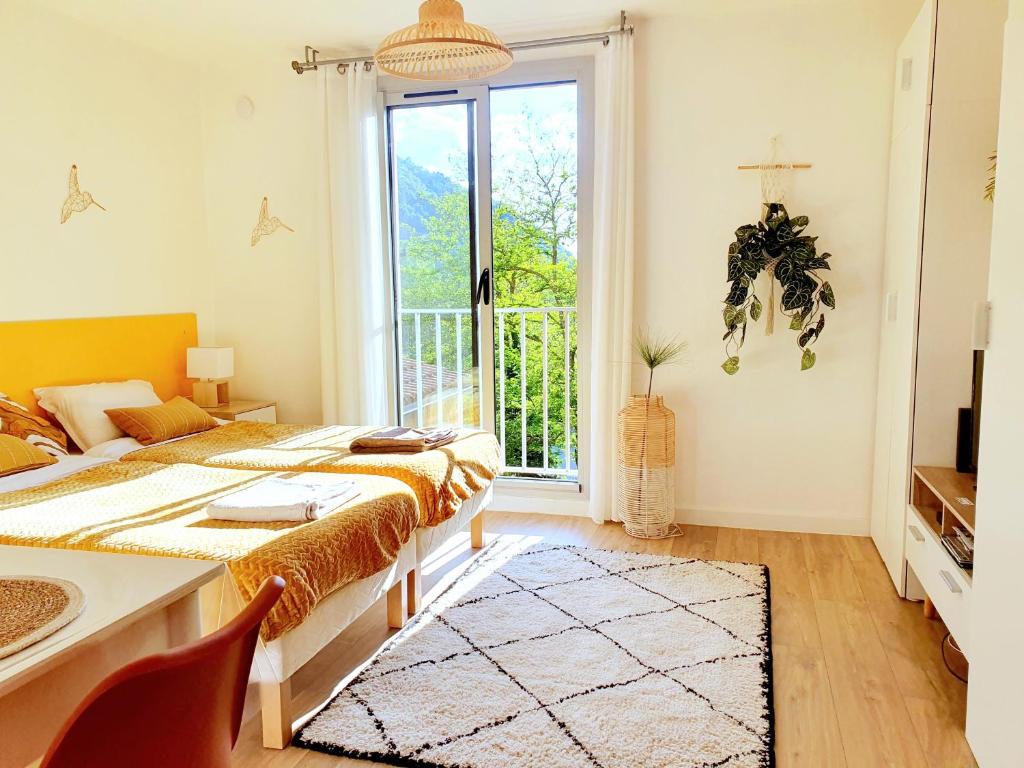 une chambre avec un lit, une table et une fenêtre dans l'établissement Charmant studio vue montagne, à Digne-Les-Bains