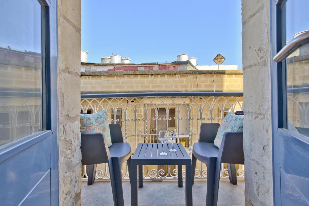 stół i krzesła na balkonie z budynkiem w obiekcie Ursula suites - self catering apartments - Valletta - By Tritoni Hotels w mieście Valletta