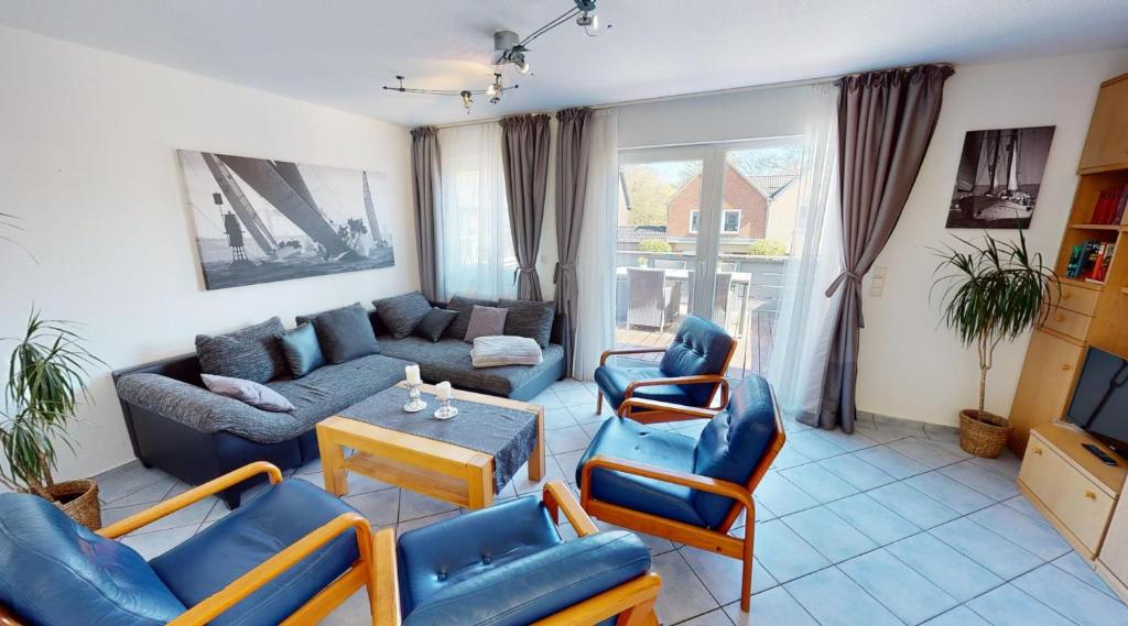 a living room with a couch and a table and chairs at Appartement-Service-Laboe Haus Seewind in Laboe