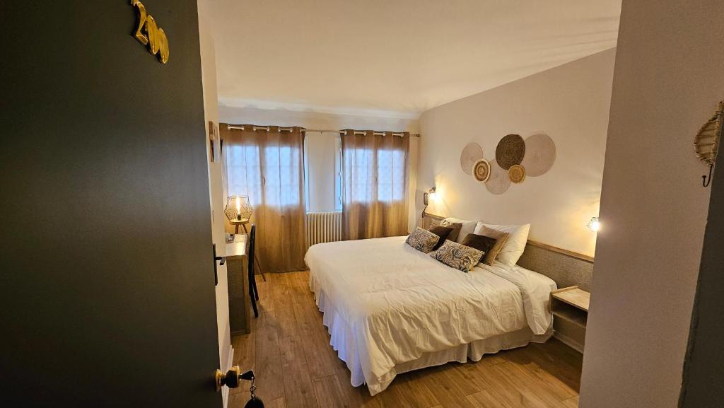 a bedroom with a white bed and a window at Auberge de la Marine in Losne