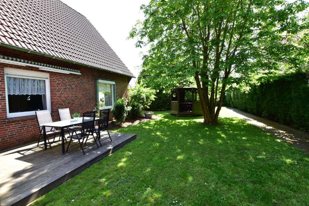 a backyard with a table and chairs and a tree at Haus Piratenperle - Hooksiel in Wangerland