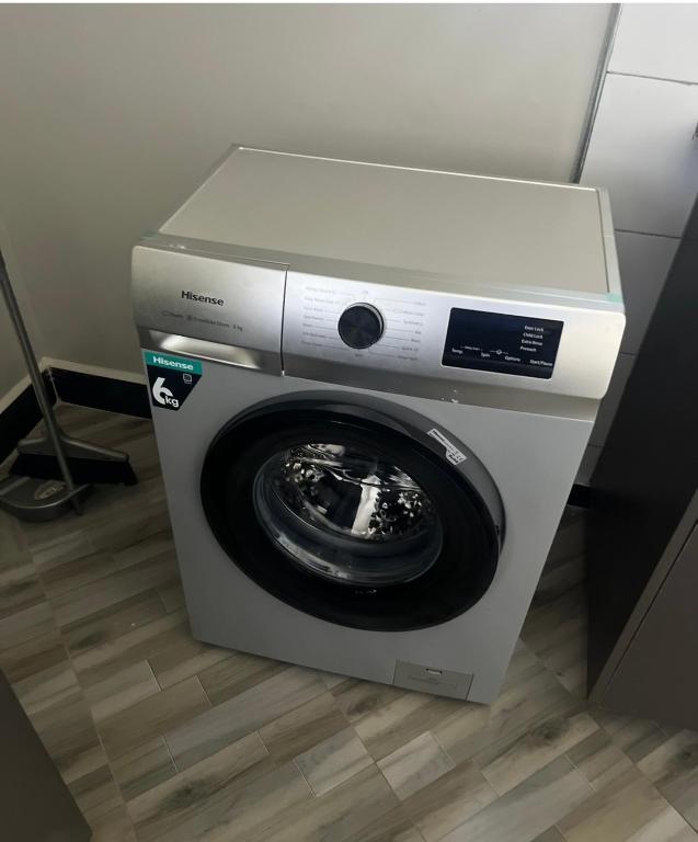 a washing machine with its door open in a room at Muntaha homes in Kampala