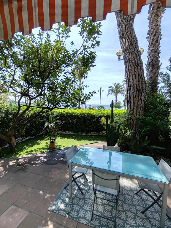 une table et des chaises assises sous un parasol dans l'établissement Garden Atlantide Promenade, à Nice