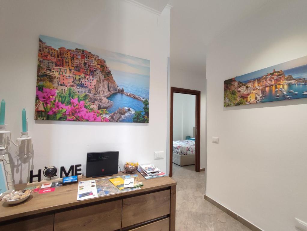 een kamer met een bureau en twee schilderijen aan de muur bij Stephy Holiday Station 5 Terre in La Spezia