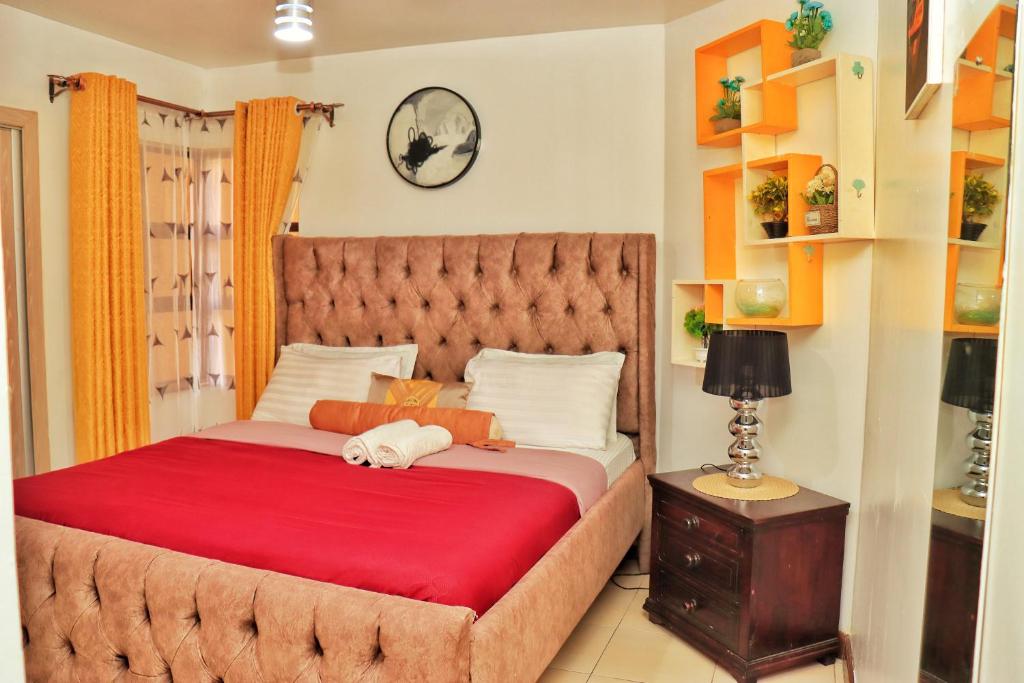1 dormitorio con 1 cama grande con manta roja en Magazi suites 3, en Nairobi