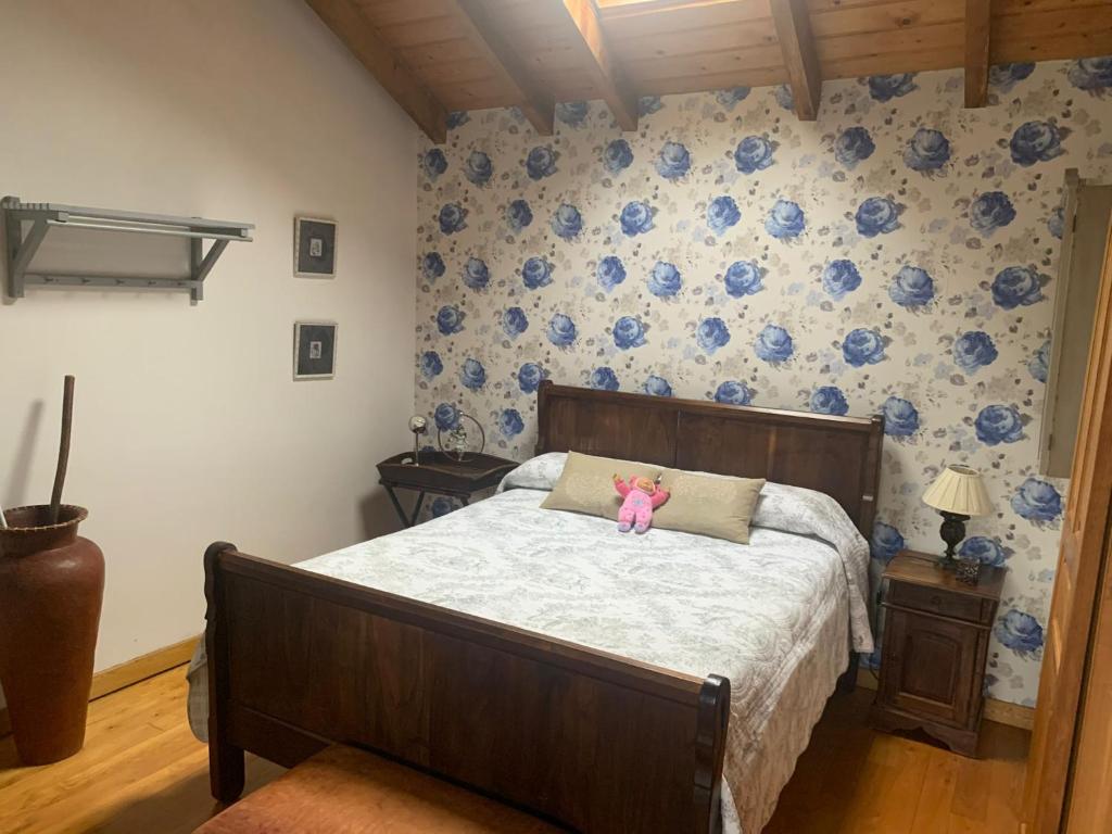 a bedroom with a bed with a teddy bear on it at La Casina de Lucia in Merodio
