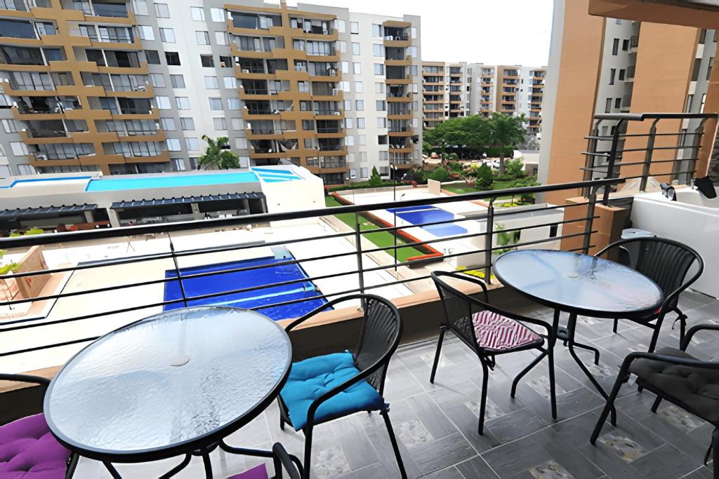 2 mesas y sillas en un balcón con edificios en Jacuzzi Privado, Relax en Ricaurte, Peñalisa en Ricaurte