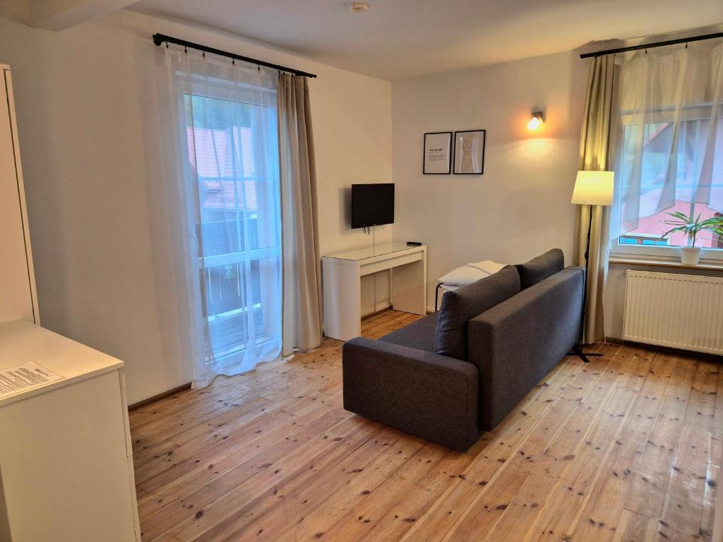 a living room with a couch and a television at Willa Roża Wiatrów in Karpacz